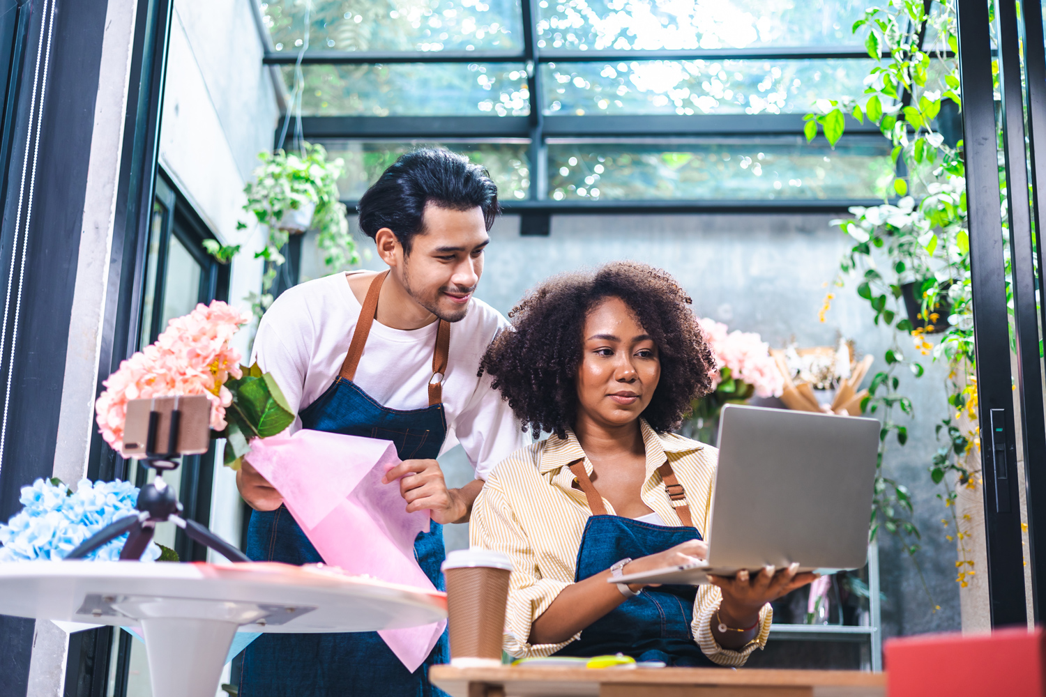 man and woman in floral shop looking at a laptop