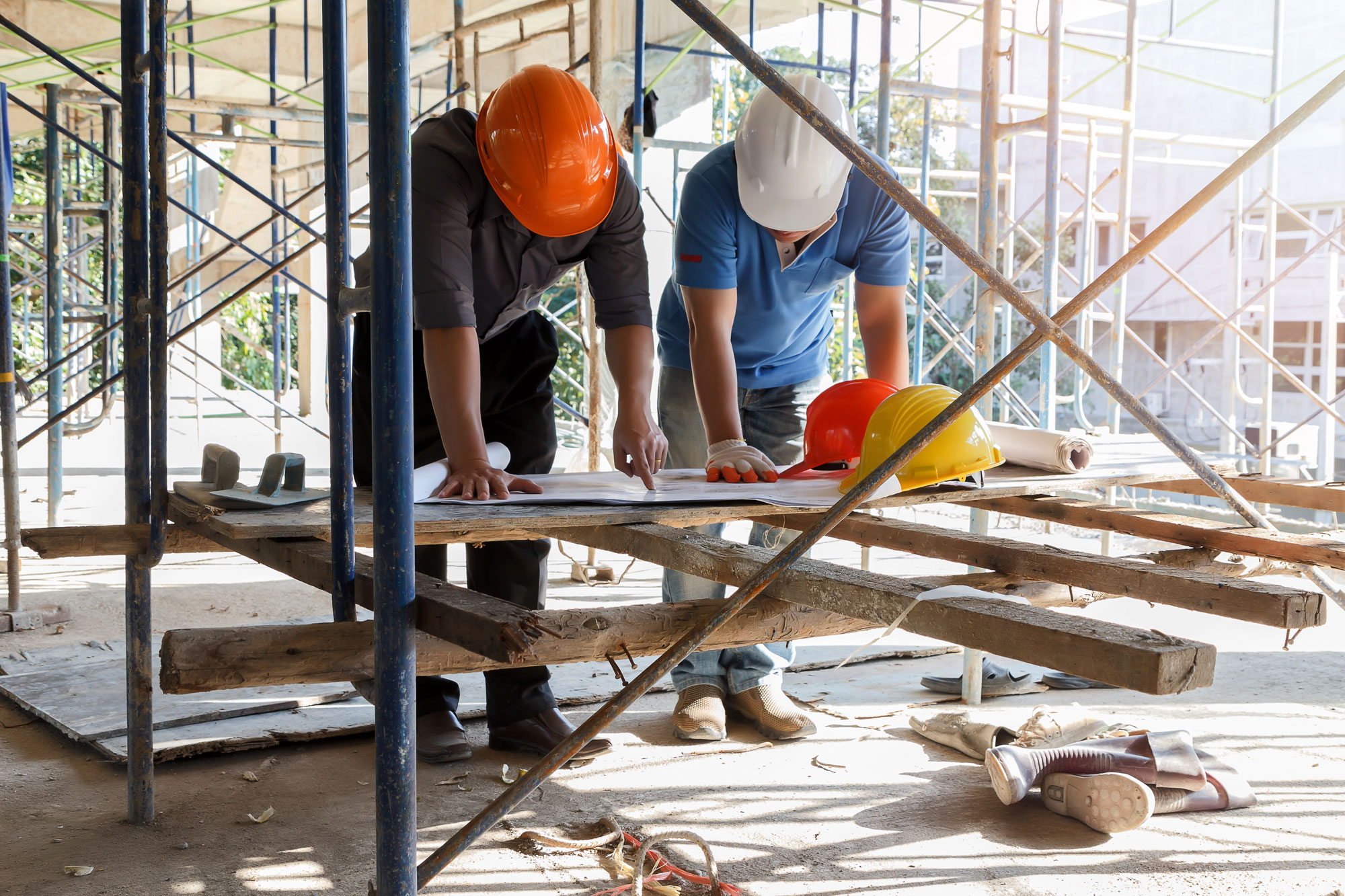 two men at construction site reviewing building plans