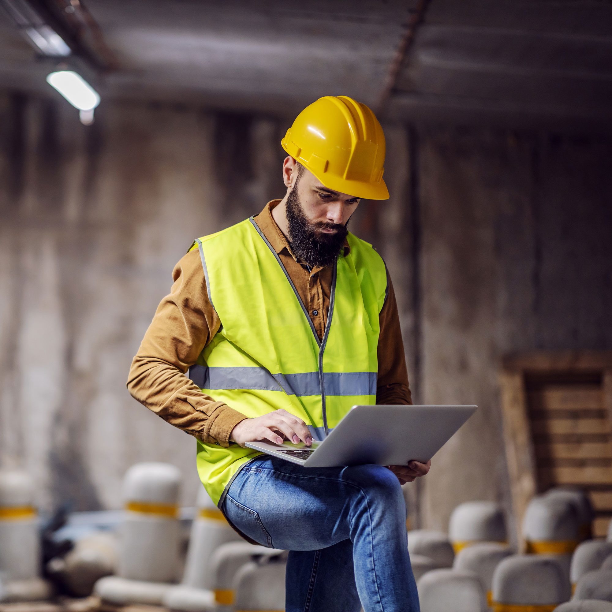 man construction worker at construction site on laptop
